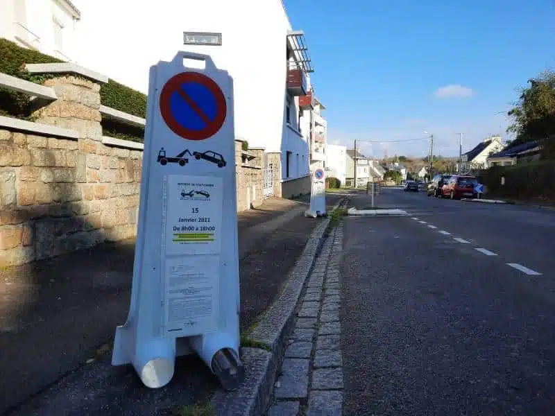 Panneau d'interdiction de stationner temporaire pour un déménagement, posé sur un trottoir.