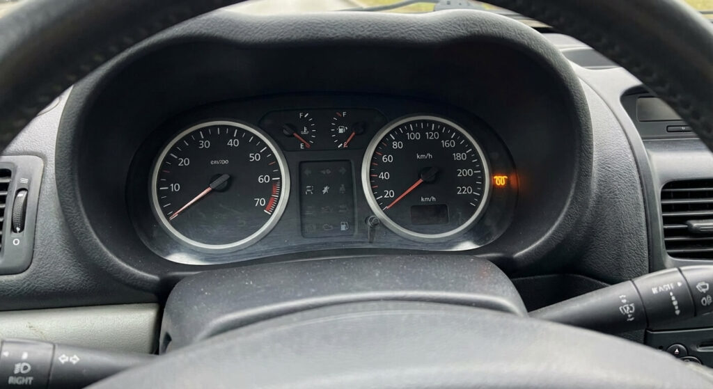 Tableau de bord de Clio 2 essence affichant le voyant orange en forme de ressort (préchauffage/électronique) allumé.