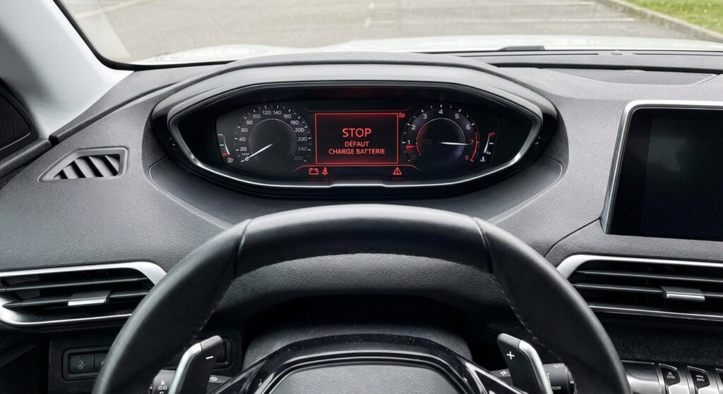 Tableau de bord affichant le message d'alerte rouge STOP "Défaut charge batterie" ou "Alimentation électrique défaillante".