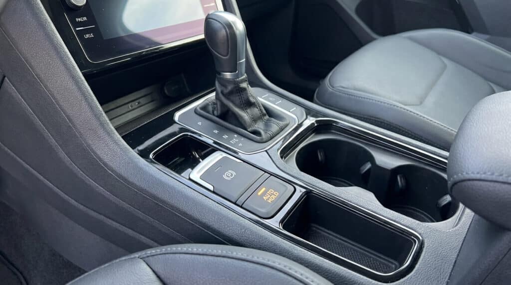 Console centrale de Volkswagen Tiguan montrant le bouton Auto Hold allumé à côté du frein de parking électrique