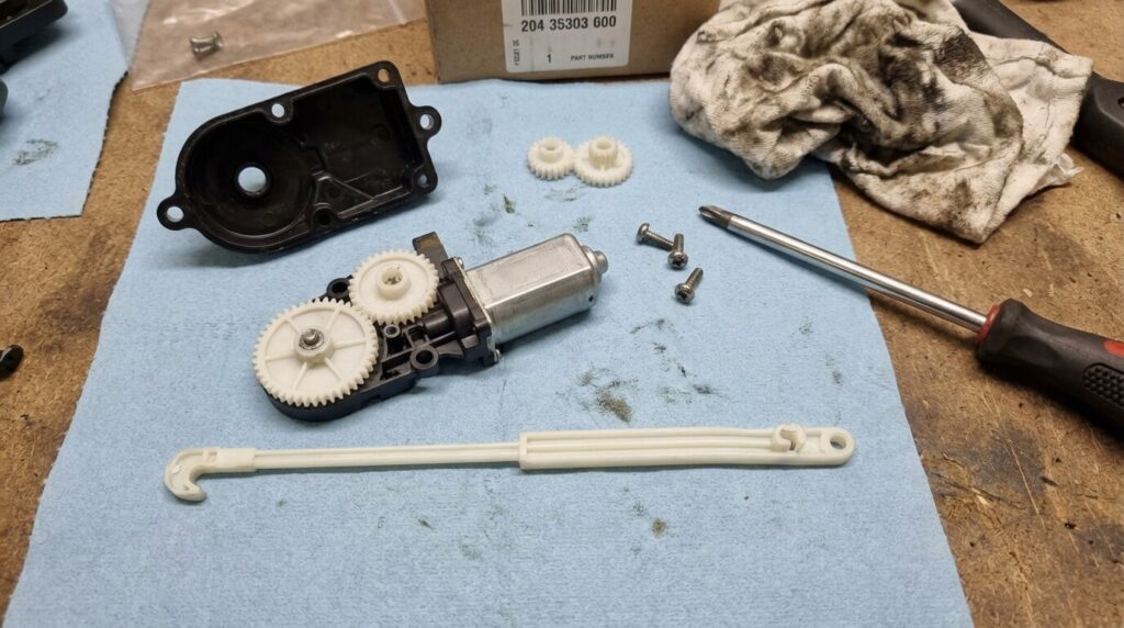 Mécanisme de moteur de verrouillage de trappe à carburant de Renault Clio 4 démonté montrant la tige en plastique