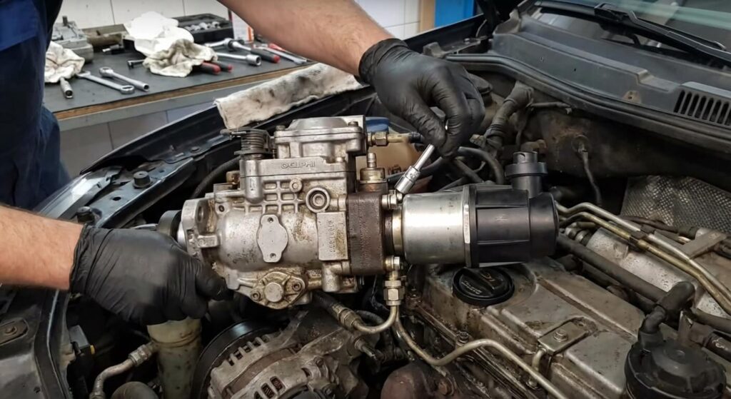 Mécanicien démontant la vanne IMV (Actuateur de débit et de pression) montée sur l'arrière de la pompe d'injection haute pression Delphi