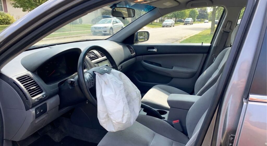 Airbag conducteur déployé à l'intérieur d'un véhicule stationné sans trace de choc frontal