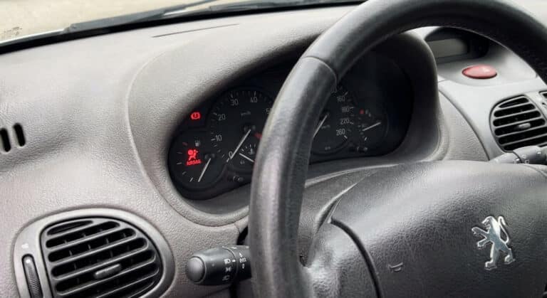 Tableau de bord de Peugeot 206 affichant le voyant rouge d'anomalie airbag allumé