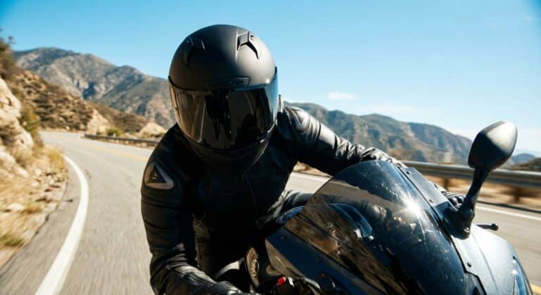 Motard portant un casque intégral équipé d'une visière noire très foncée en plein jour