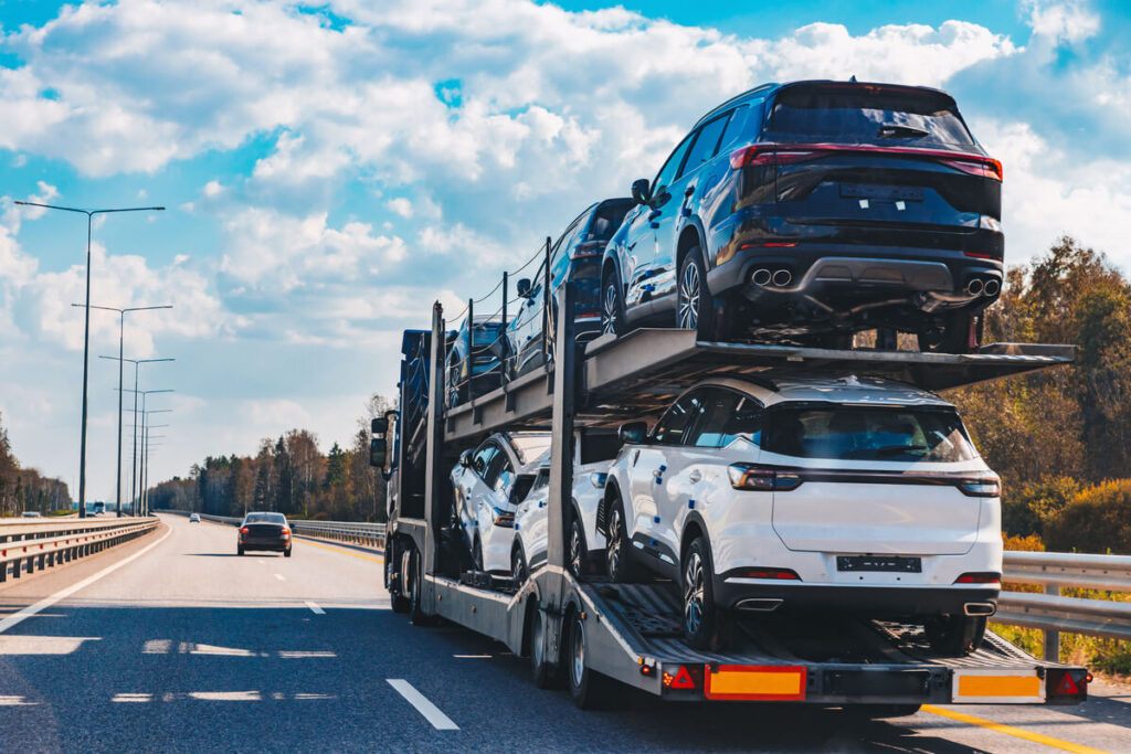 Ce que peu de gens savent sur le transport de voiture en Europe 2 Un camion porte-voitures circulant sur une autoroute européenne, illustrant le transport de véhicules longue distance.
