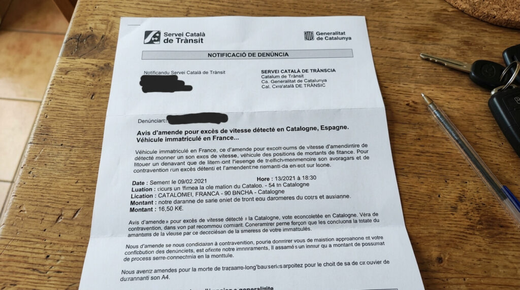 Lettre de contravention en français du Servei Català de Trànsit posée sur une table.