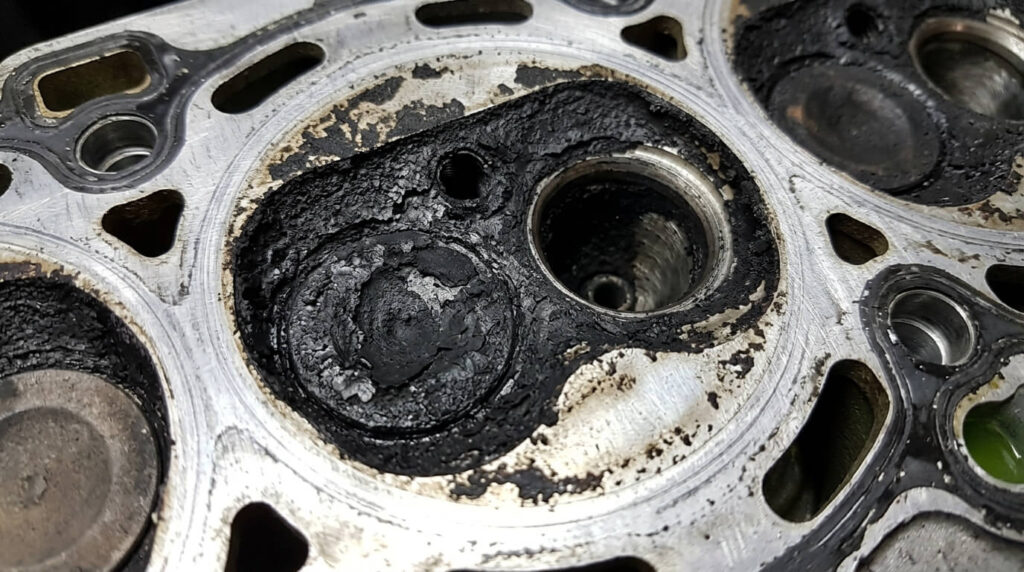 Vue macroscopique de la calamine sur la culasse en aluminium d'un moteur 316 CDI