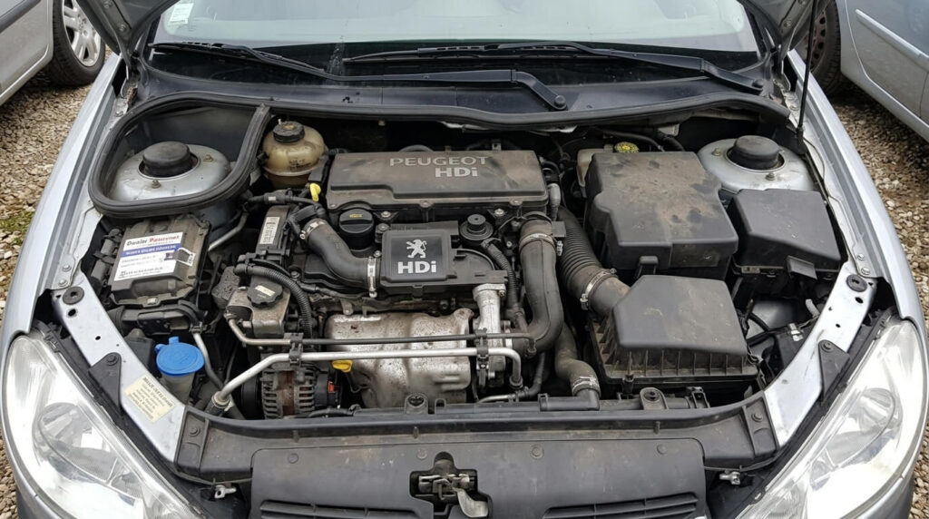 Le bloc moteur diesel 1.4 HDi sous le capot d'une Peugeot 206 d'occasion.