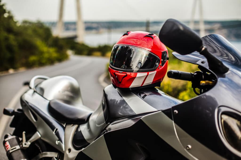 Assurance moto : comment choisir la bonne formule et payer moins cher ? 3 Un casque de moto posé à côté d'une calculette pour simuler le prix d'une cotisation.