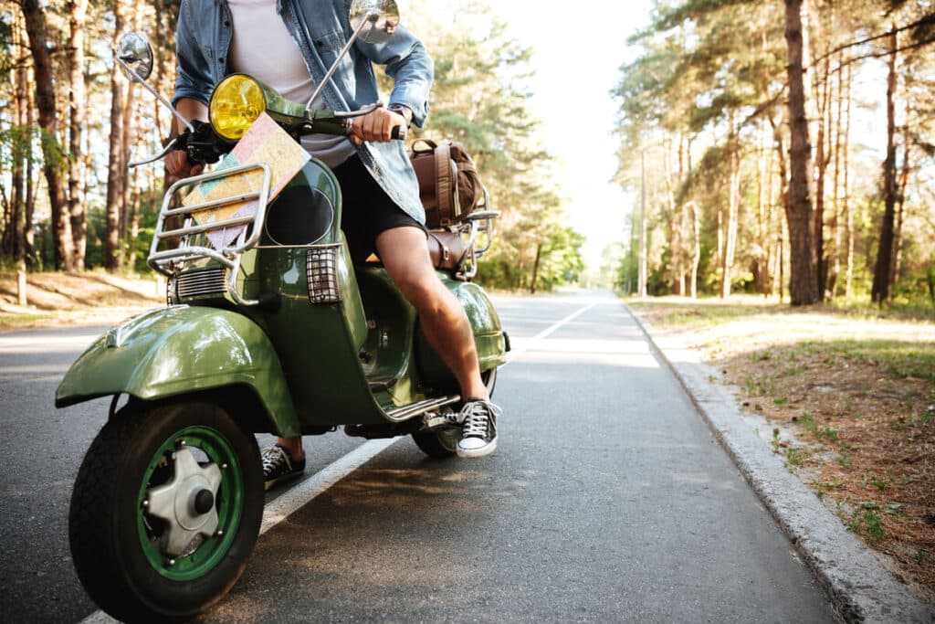 EQU B sur un permis de conduire : qu'est-ce que ça signifie ? 3 Un conducteur circulant en ville au guidon d'un scooter 125cc léger.