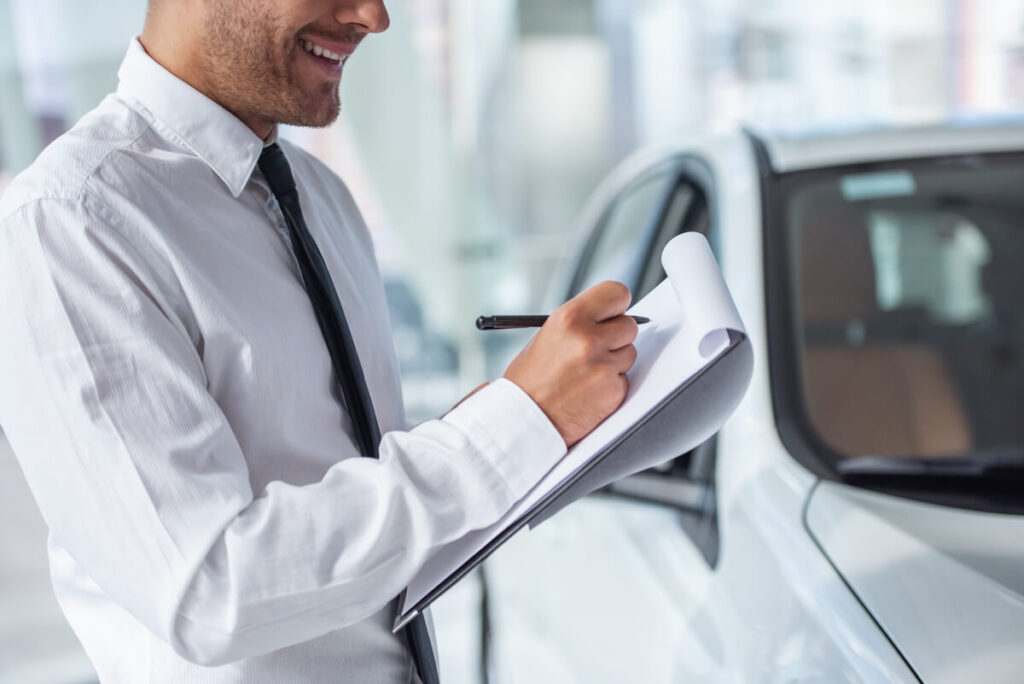 Un acheteur examinant le carnet d'entretien et l'historique des factures d'une voiture d'occasion.