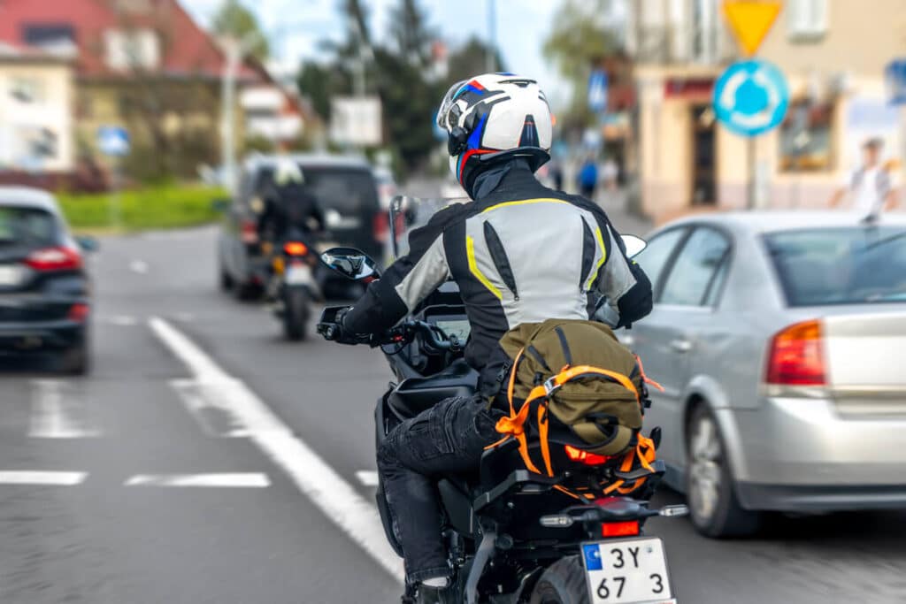 Assurance moto : comment choisir la bonne formule et payer moins cher ? 4 Un conducteur à moto circulant en toute sécurité sur une route dégagée.