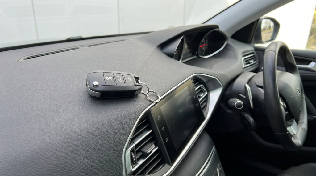 Ouverture main libre Peugeot 308 qui ne fonctionne plus : causes et solutions 2 La clé télécommande d'une Peugeot 308 posée sur le tableau de bord du véhicule.