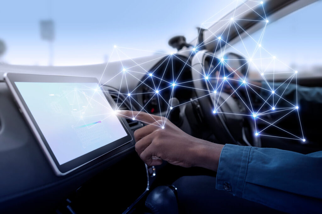 Un conducteur utilisant l'écran tactile connecté de sa voiture affichant des données de navigation et d'applications.