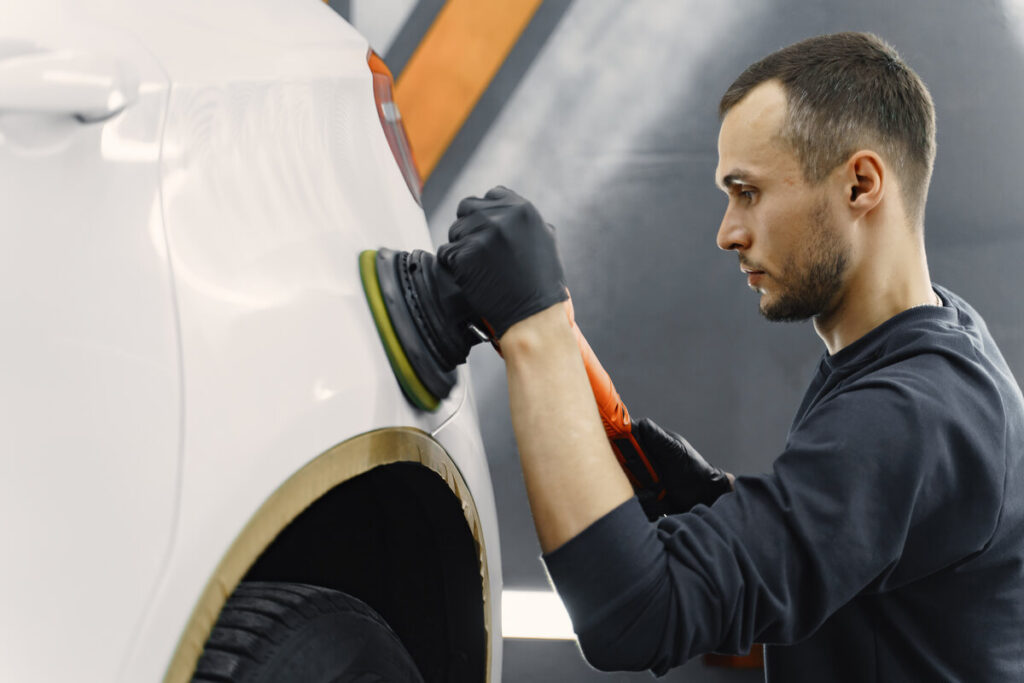 Préparation et ponçage des éléments de carrosserie avant l'application du vernis.