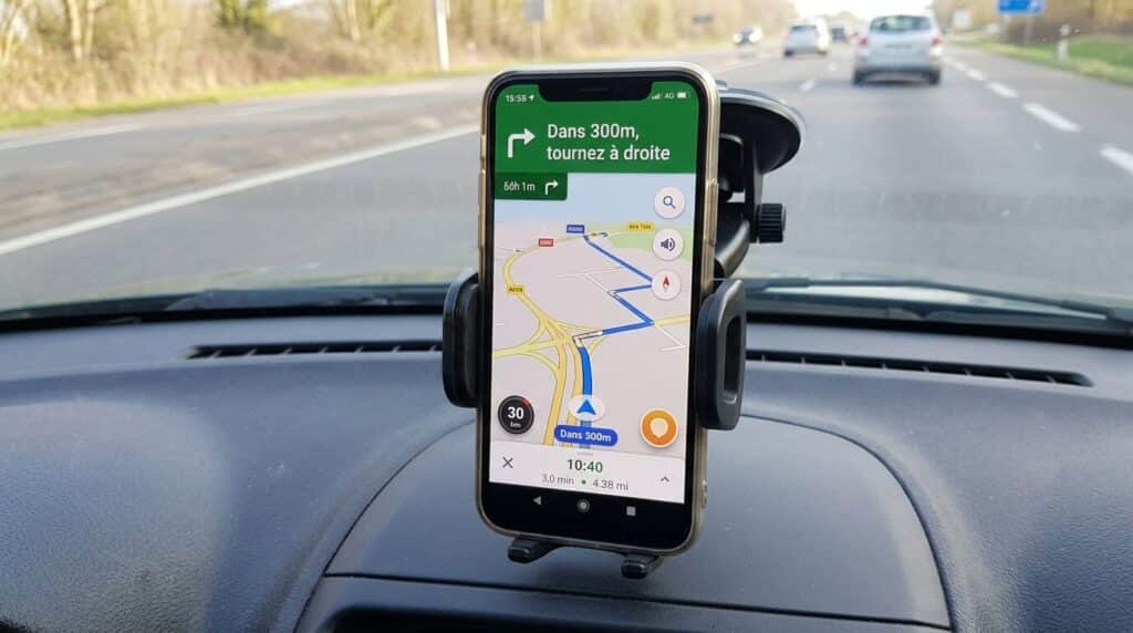 Que devient Inforad, l'avertisseur de radars français ? 3 Un smartphone fixé sur un support de pare-brise affichant une application moderne de navigation routière.