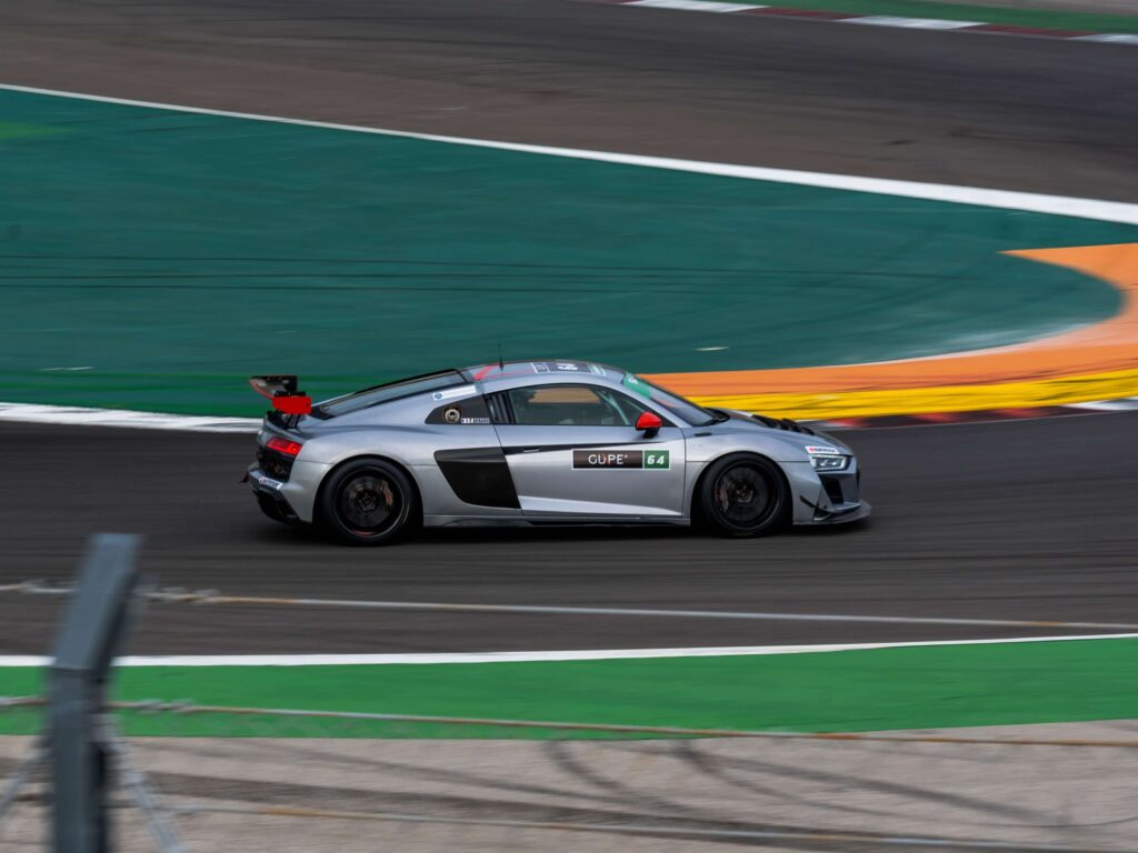 Stage de pilotage voiture : comment bien choisir son expérience sur circuit ? 3 Voiture de sport lancée à pleine vitesse dans une courbe lors d'un stage de pilotage.