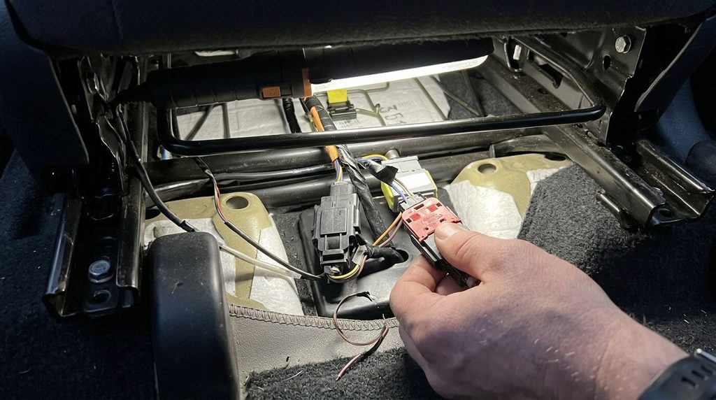 Faisceau et connecteur électrique sous le siège passager d'une Clio 2 pour résoudre le faux contact airbag.