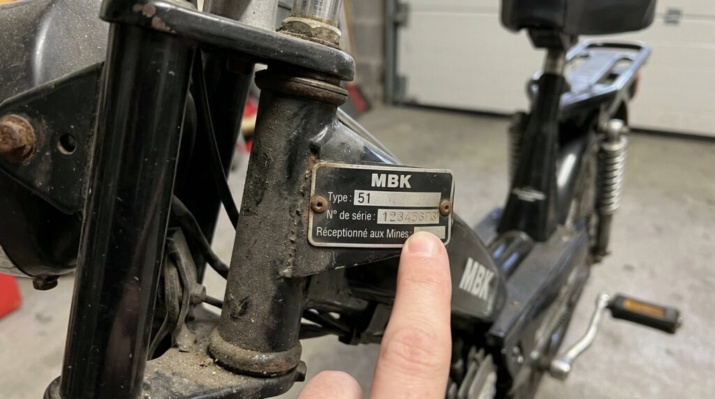 Plaque des mines rivetée sur le cadre d'un cyclomoteur MBK 51 pour relever le numéro de série.