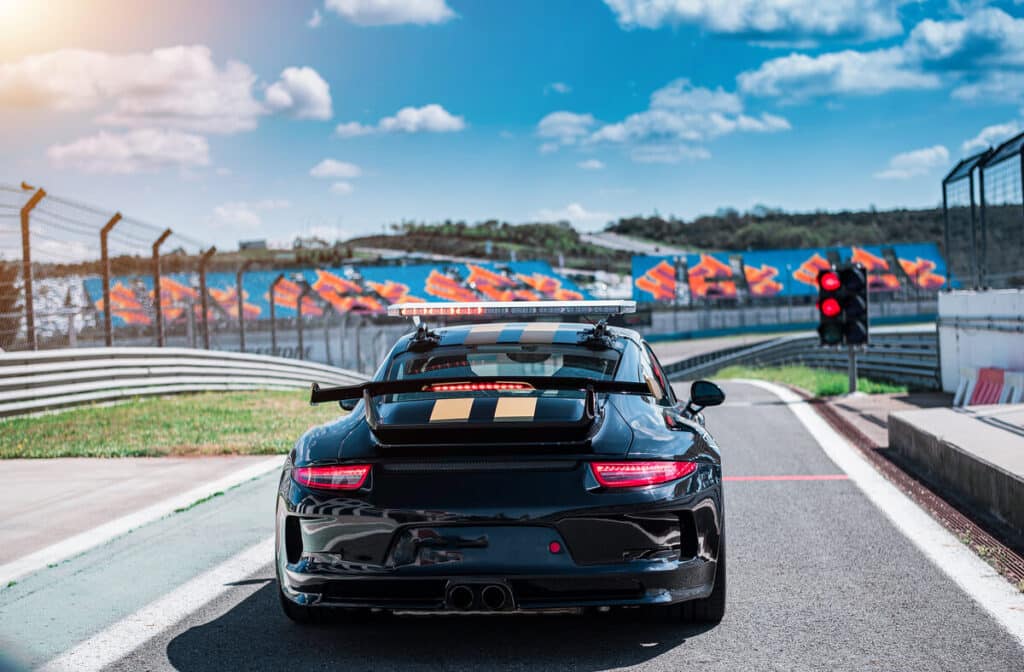 Stage de pilotage voiture : comment bien choisir son expérience sur circuit ? 2 Alignement de supercars Ferrari et Porsche prêtes pour un stage de pilotage sur circuit fermé.