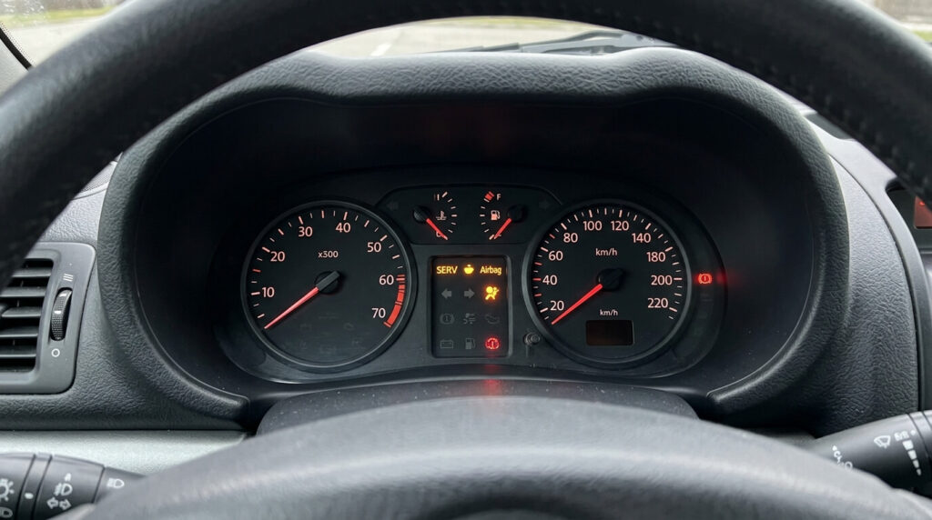 Tableau de bord de Renault Clio 2 avec le voyant SERV et le voyant Airbag allumés simultanément en orange.