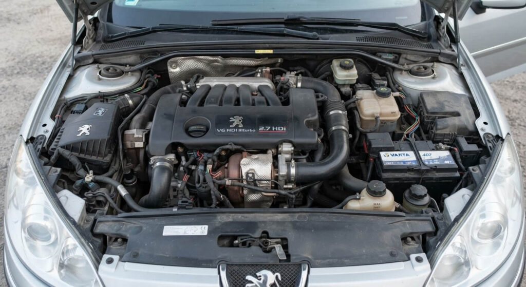 Problème moteur 2.7 V6 HDI : les pannes les plus fréquentes à connaître 2 Bloc moteur 2.7 V6 HDi biturbo installé dans le compartiment moteur d'une berline routière.