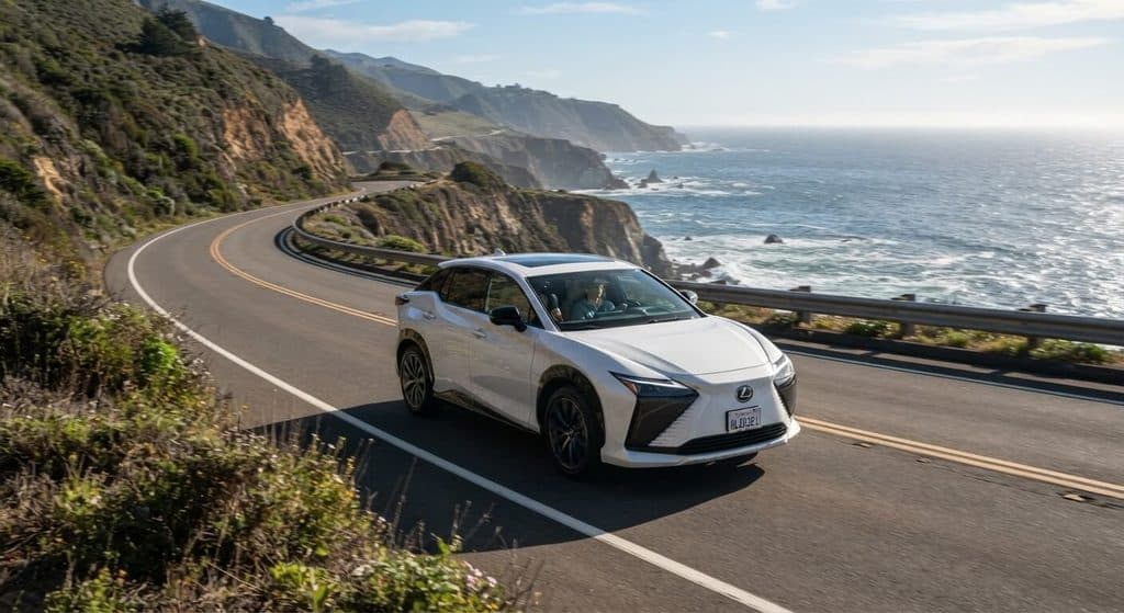 SUV électrique Lexus blanc roulant sur une route côtière.