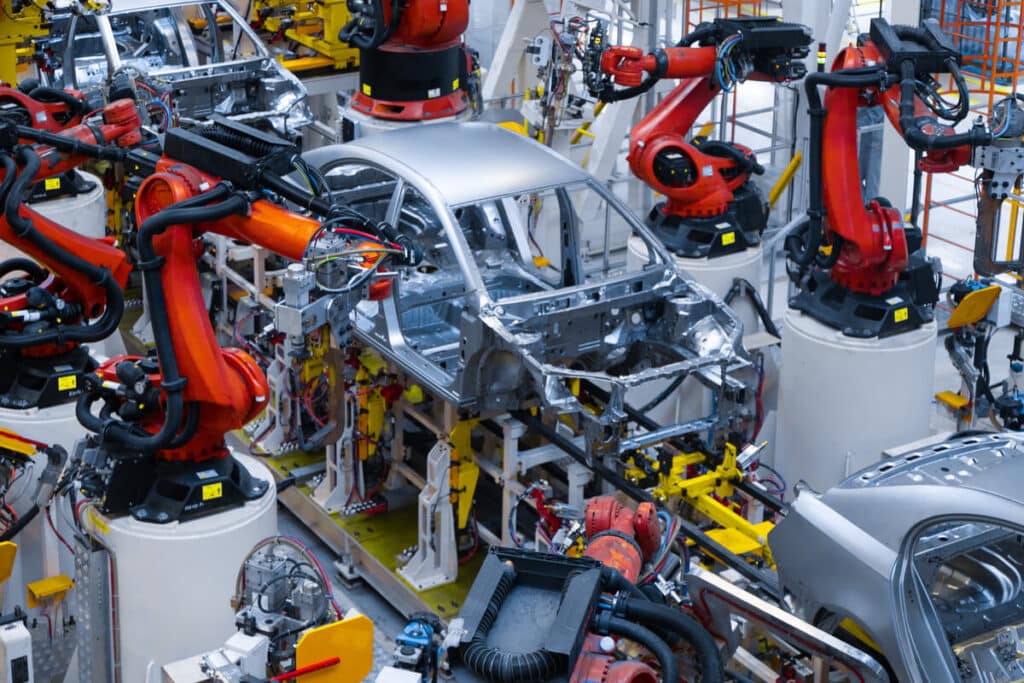 Bras robotisés assemblant la carrosserie d'un véhicule sur une chaîne de production automobile en Thaïlande.