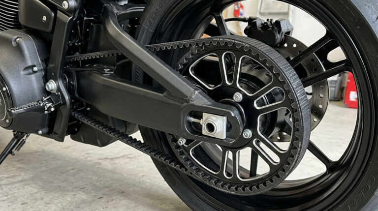 Courroie crantée renforcée en fibre de carbone entraînant la poulie arrière d'une moto.