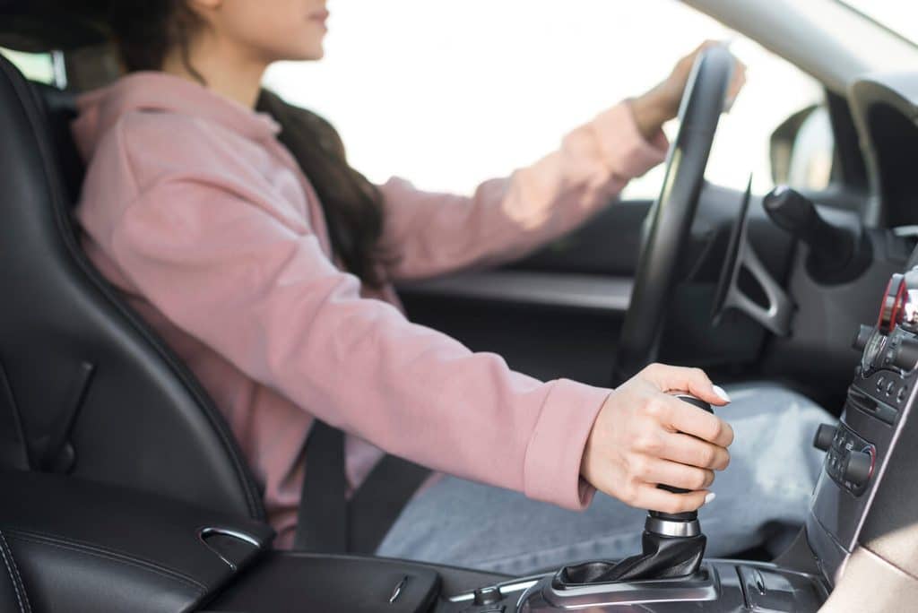 Permis raté 15 fois : que faire pour enfin l’obtenir ? 3 Gros plan sur le levier de vitesse d'une voiture d'auto-école en boîte automatique simplifiée.